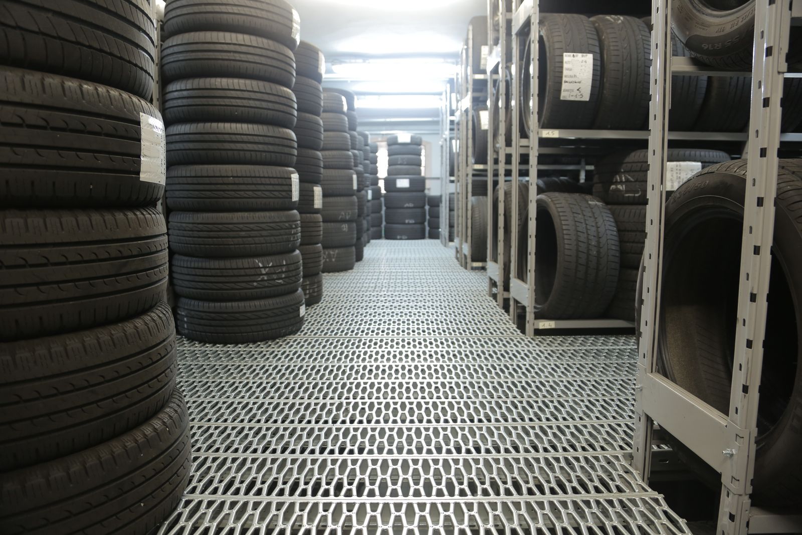 Rows of new tires stacked floor to ceiling in a tire warehouse
